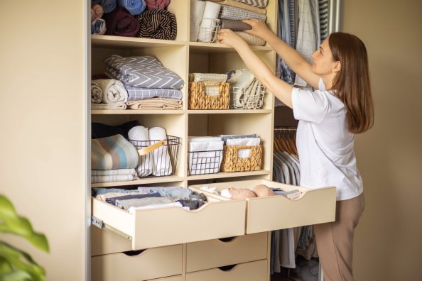 A woman is organizing a tidy closet.