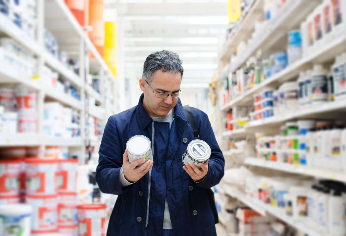 Man choosing paint in a hardware store.