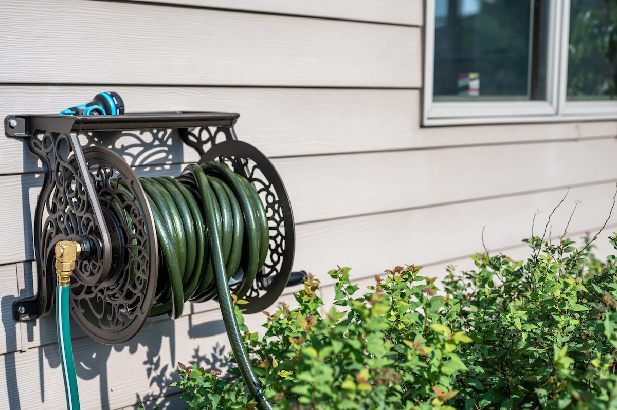 A hose reel mounted to the side of a house.