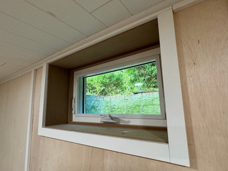After photo of a trimmed basement window.