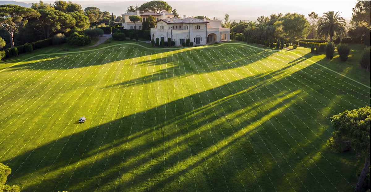 A Mammotion lawn mower moving through a pre programmed mowing pattern.