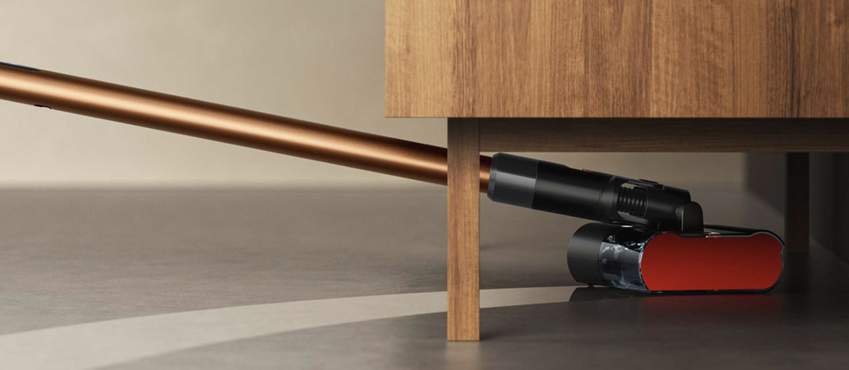 Dyson’s PencilWash™ Wet Cleaner cleaning under a piece of wood furniture