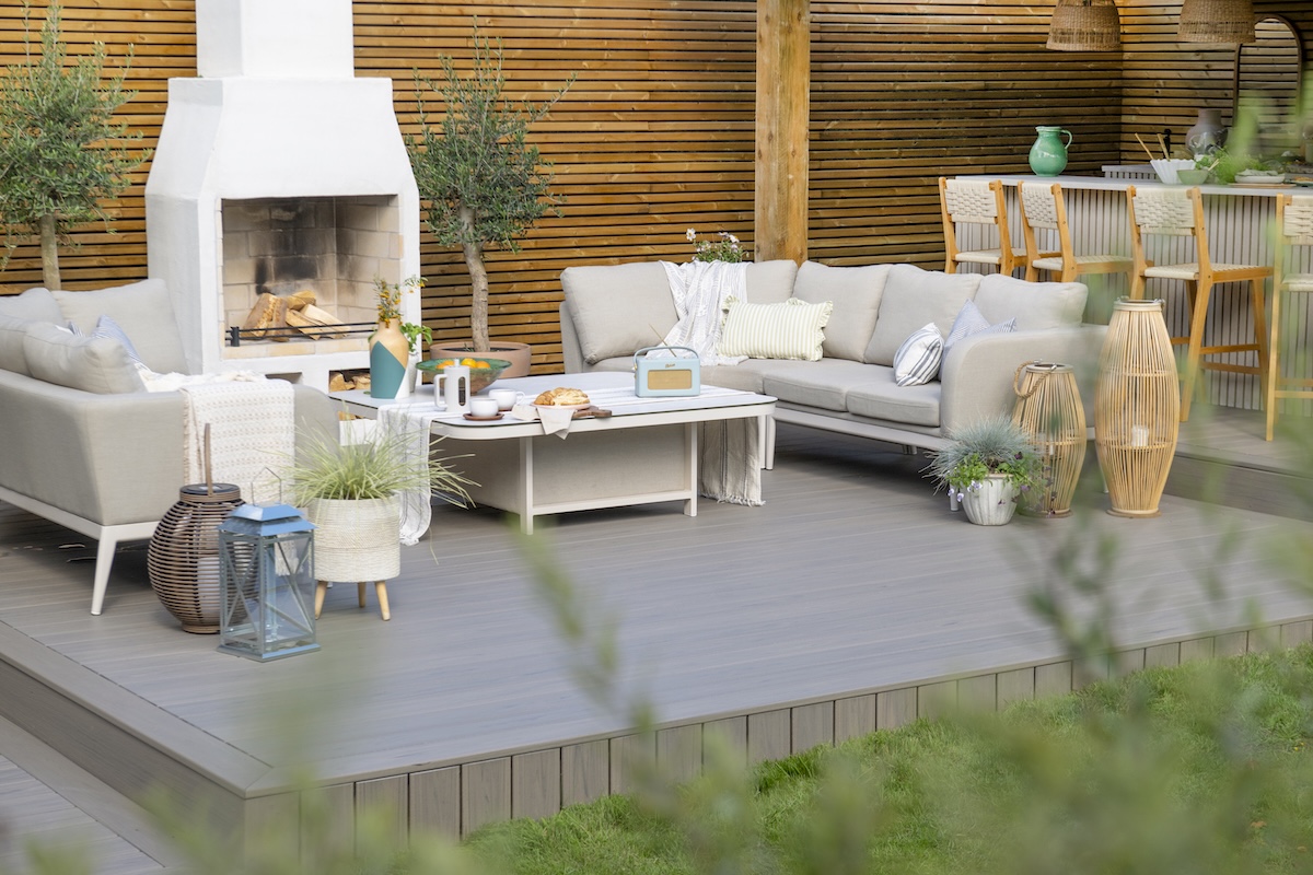 A beautiful Trex composite deck styled with seating and an outdoor fireplace.