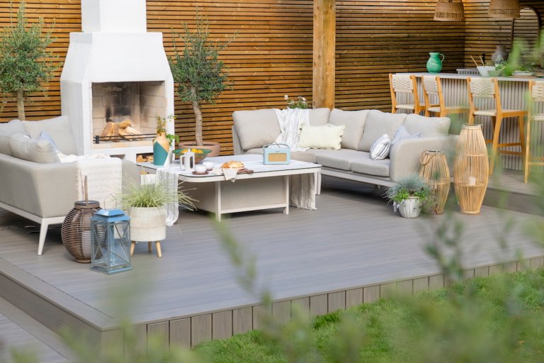 A beautiful Trex composite deck styled with seating and an outdoor fireplace.