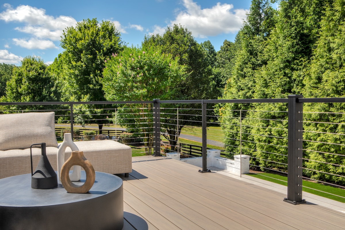 Trex composite decking with a cable railing with a beautiful backyard.
