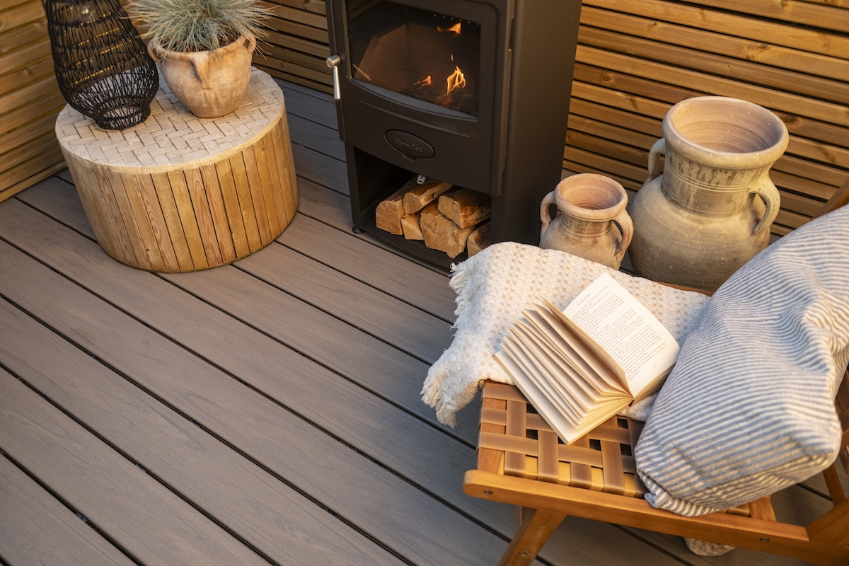 Close up of Trex decking with chairs and a wood burning stove.