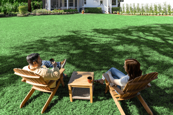A couple sitting on a beautiful lawn cared for by TruGreen experts.