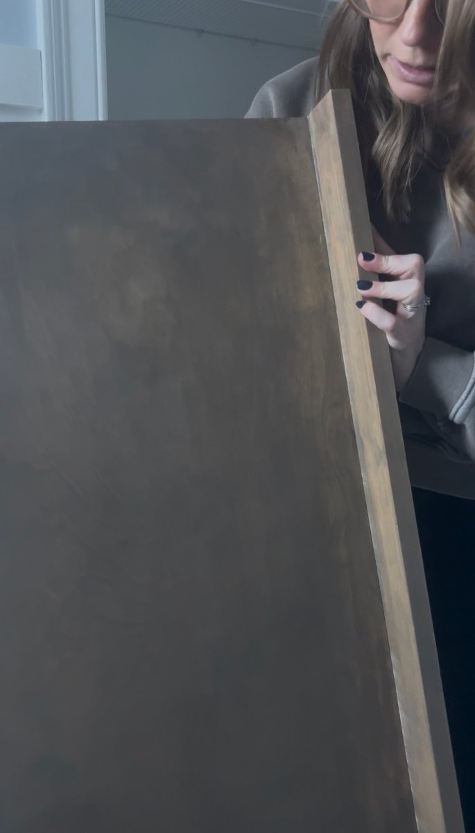 Caitlin Frank holding a wood cover for wire shelves.
