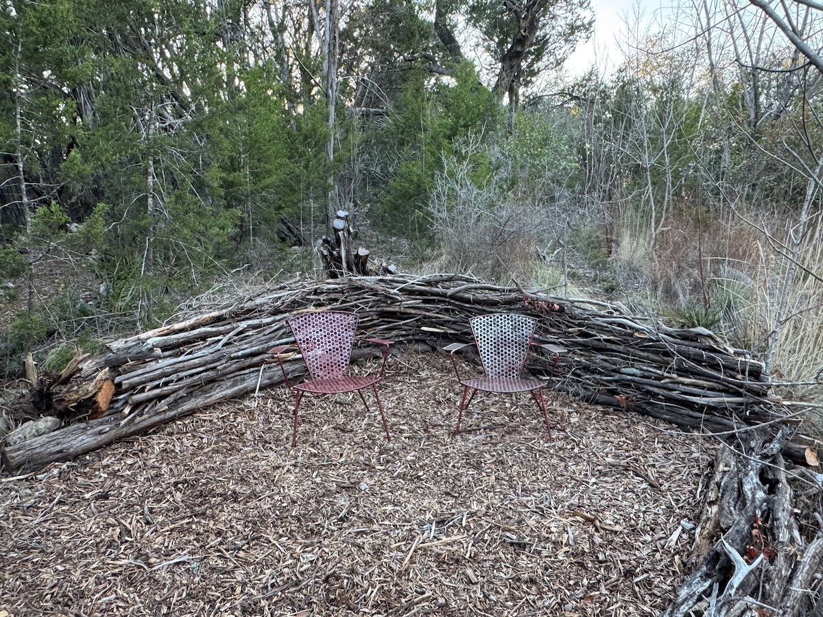 Dead hedges as a backdrop for a viewing area with two chairs.