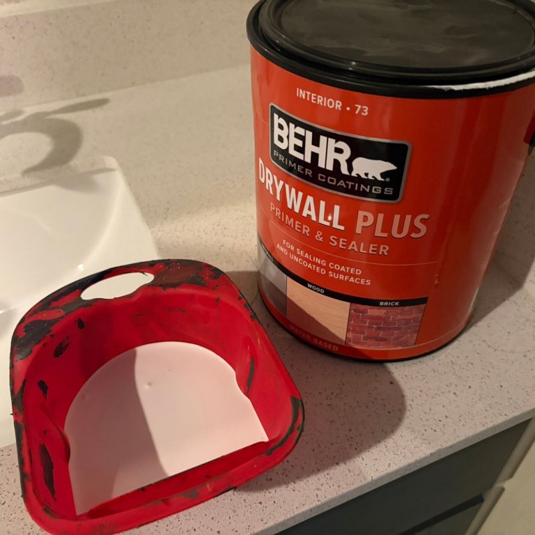 Behr Drywall Plus Primer poured into a paint bucket during testing