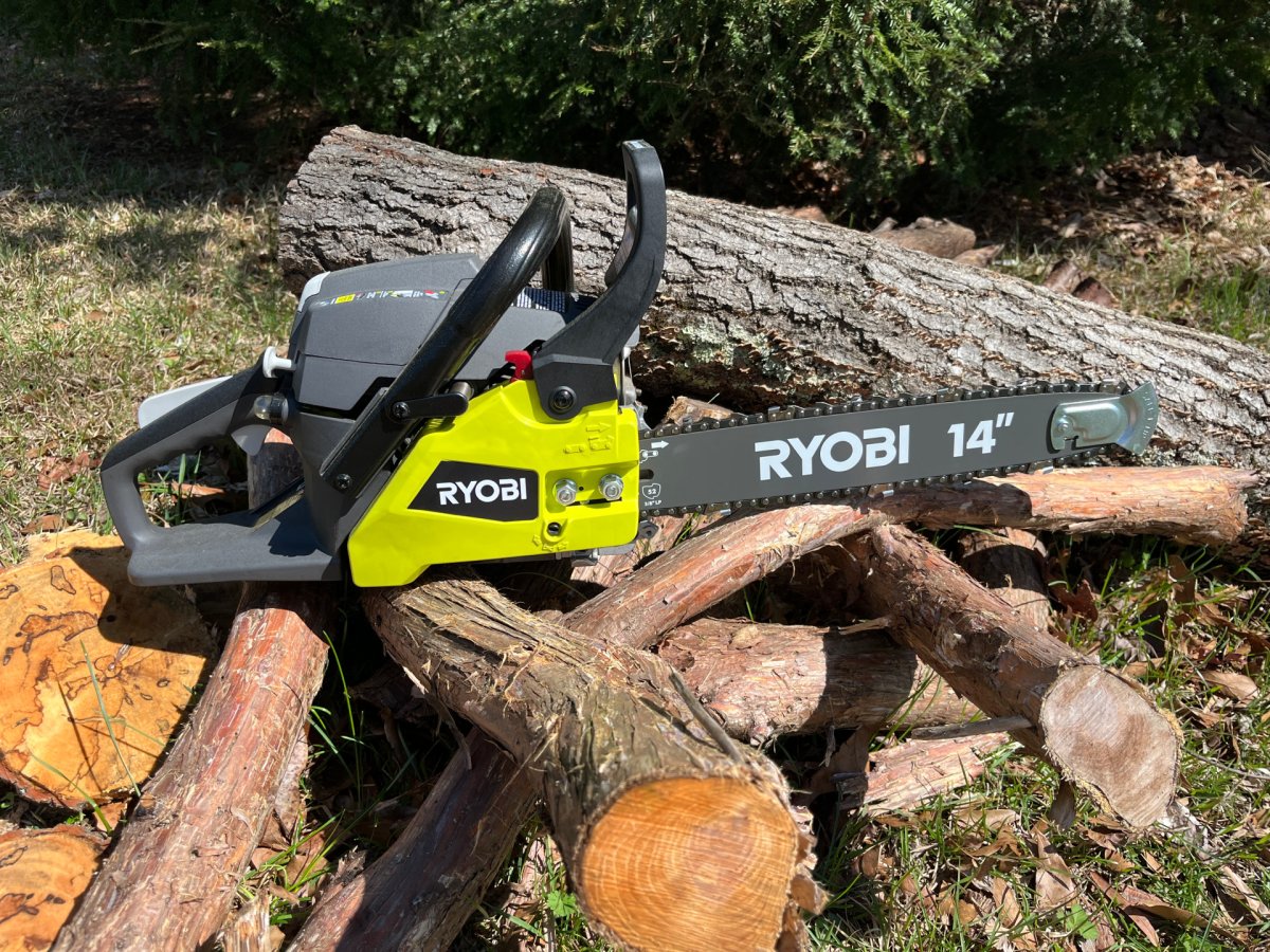 The Ryobi 14-Inch 37cc 2-Cycle Gas Chainsaw on a pile of cut wood during testing 