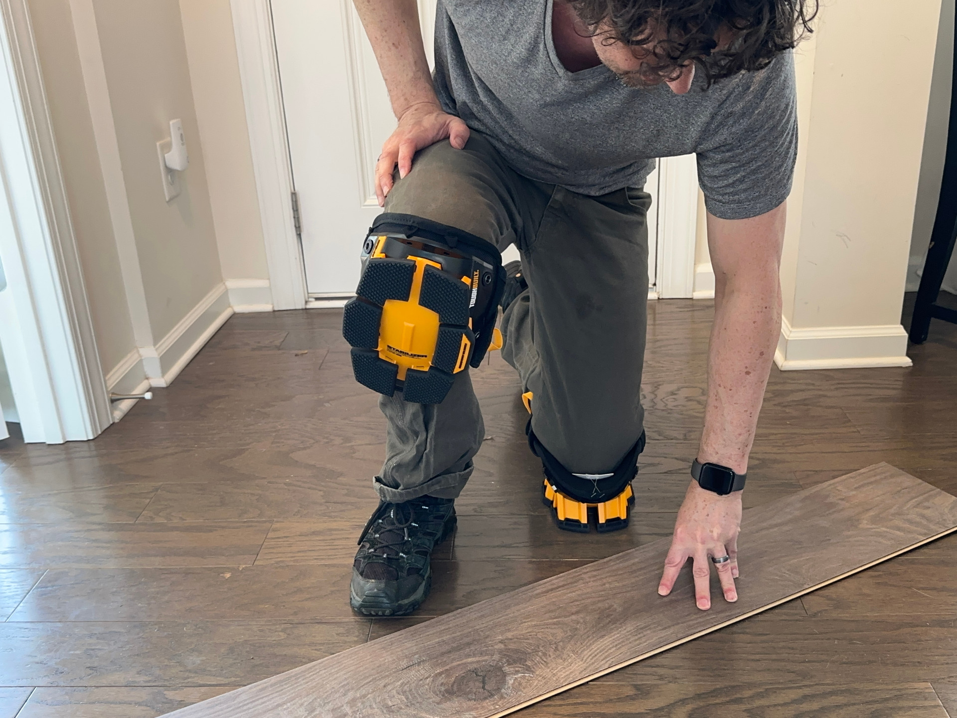 A person wearing a pair of the best knee pads while installing flooring during testing