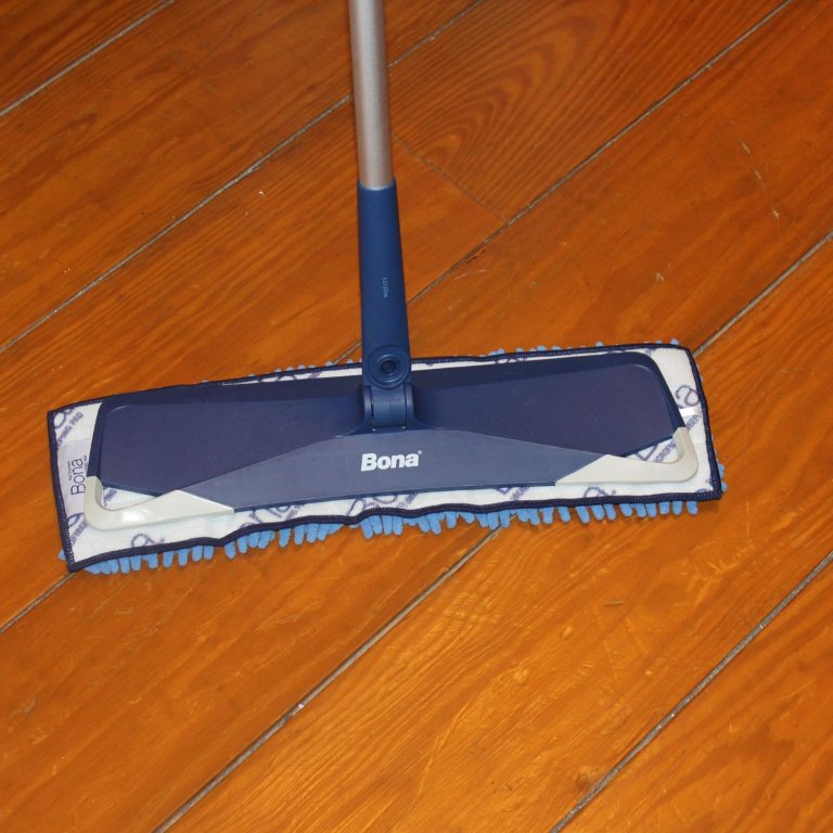 A product tester using the Bona Premium Sweep & Clean Mop to clean a hardwood floor