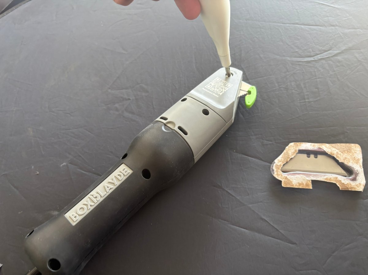 Using a small screwdriver to open the Boxblayde blade housing for replacement