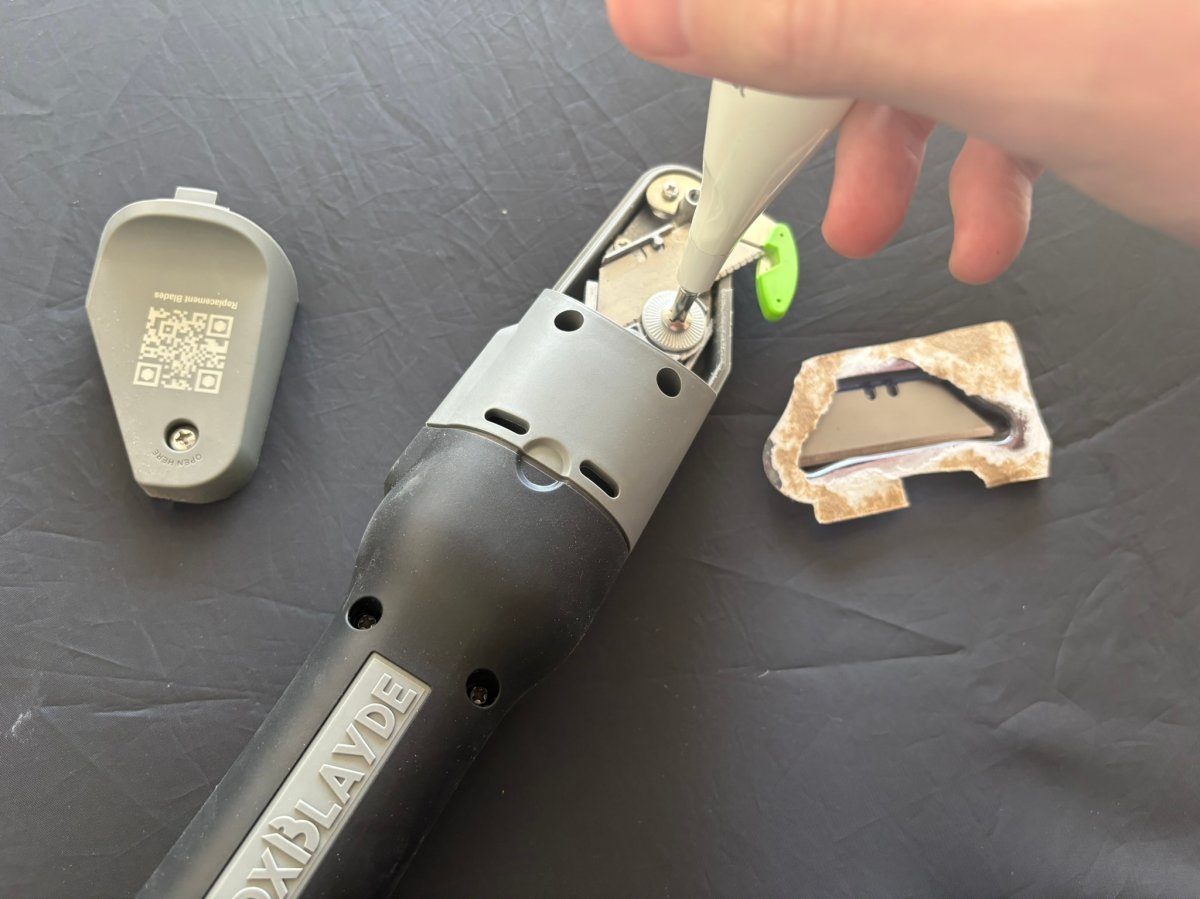 Using a small screwdriver to open the Boxblayde blade housing for replacement
