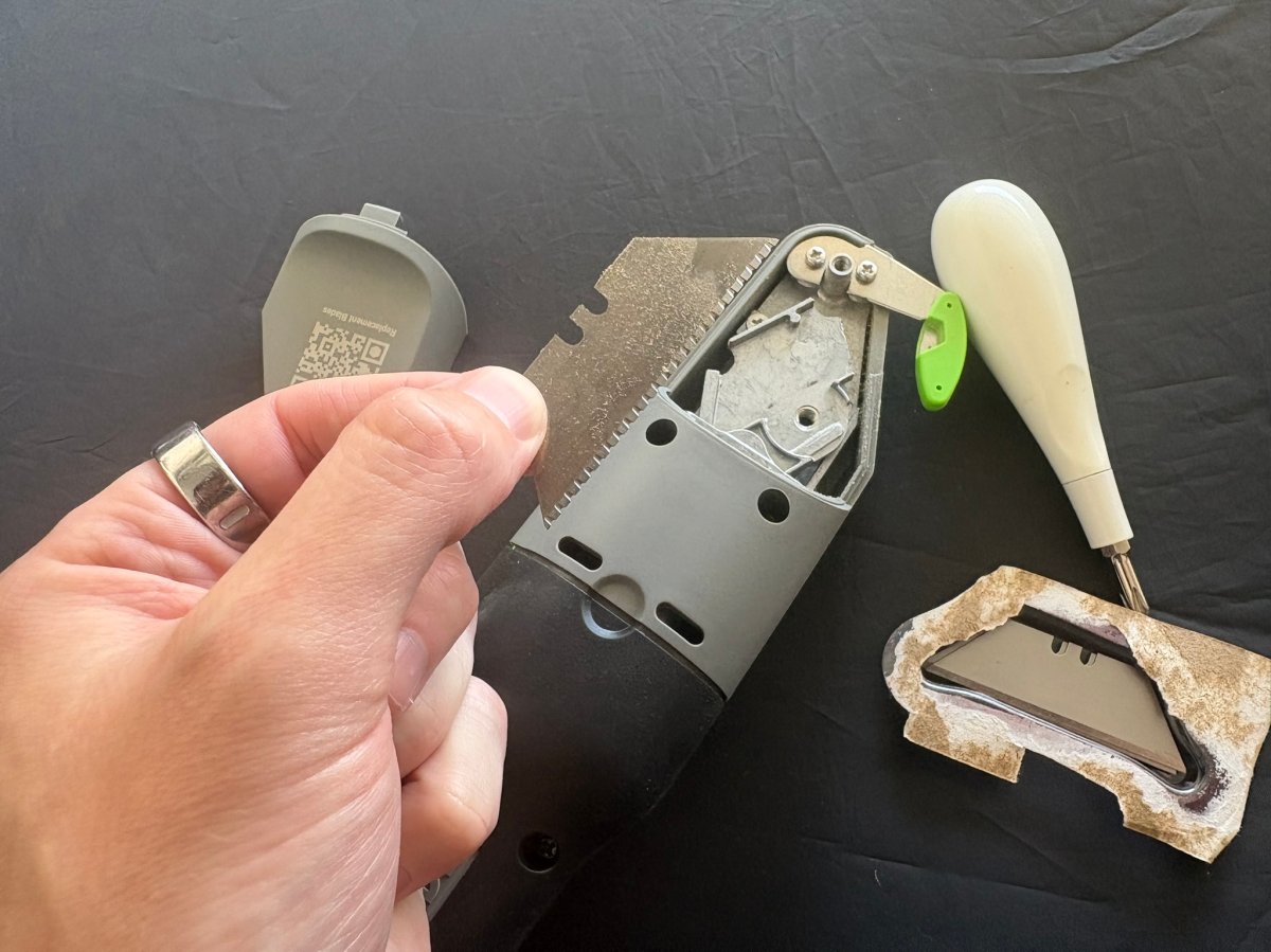 A product tester holding a used blade from the Boxblayde electric cardboard cutter