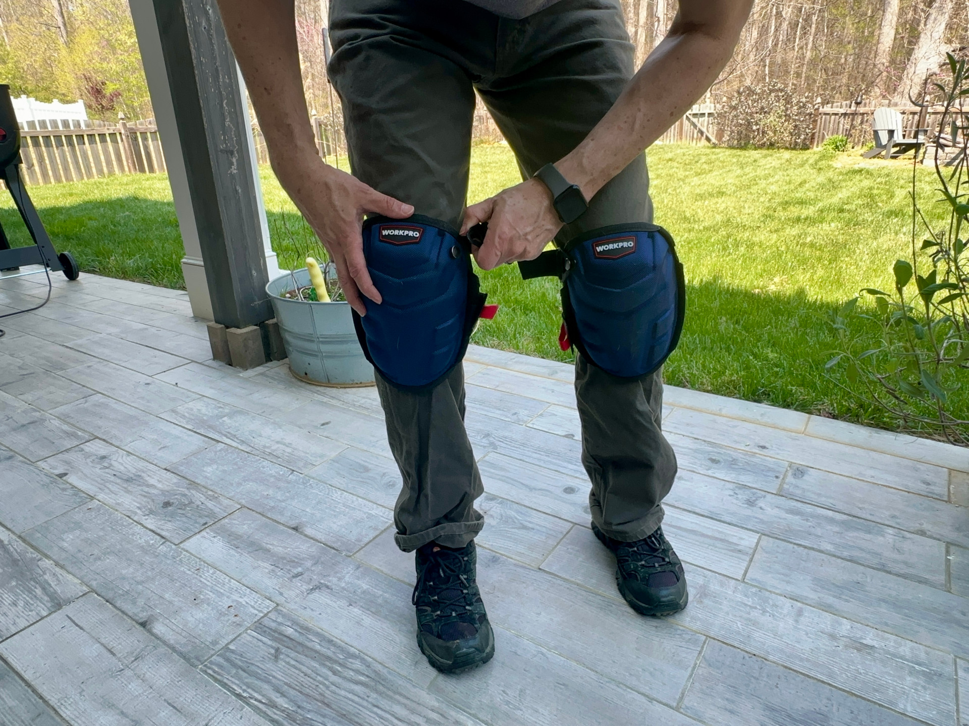 A person adjusting a WorkPro knee pads during testing