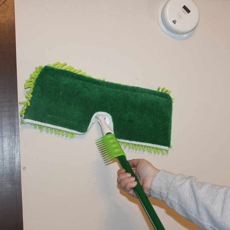 A product teter using the Libman 2-Sided Microfiber Dust Mop to clean a wall