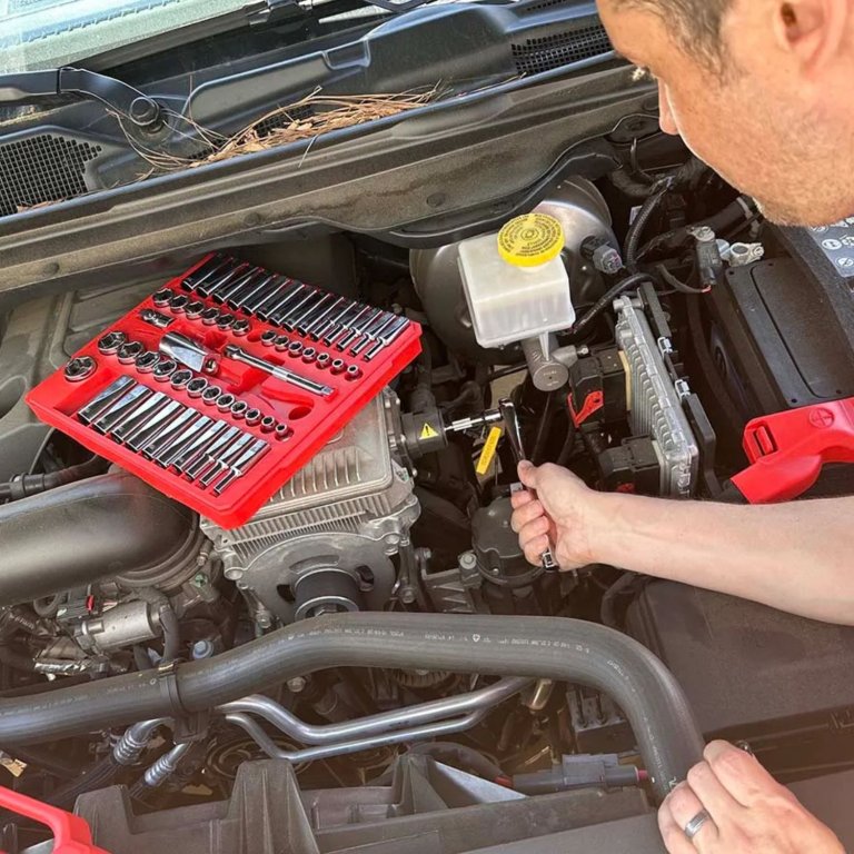 A product tester using the Milwaukee 3/8-Inch Drive 56-Piece Ratchet and Socket Set to work on a car