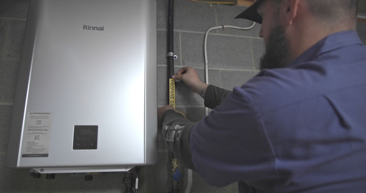 A technician installing a propane-powered appliance in a home.