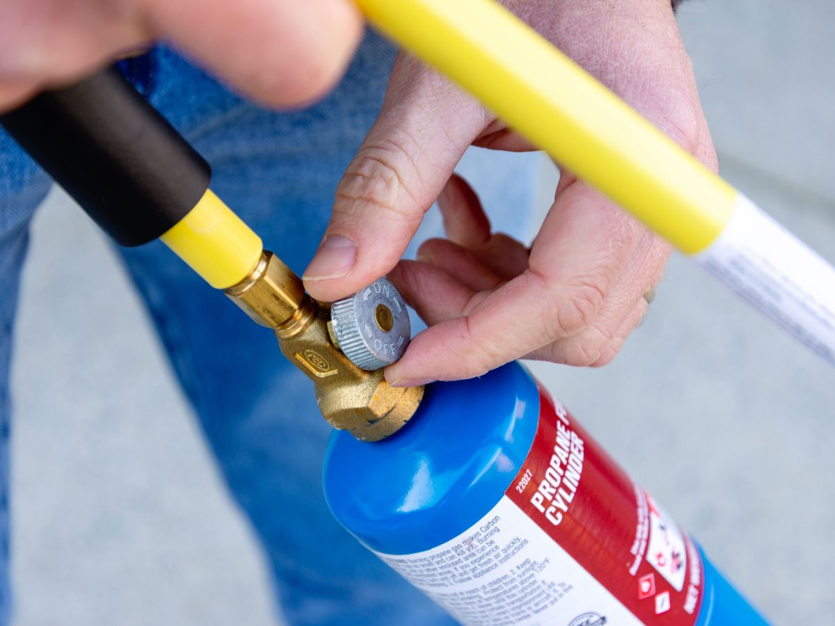 Turning the knob to close a weed torch.