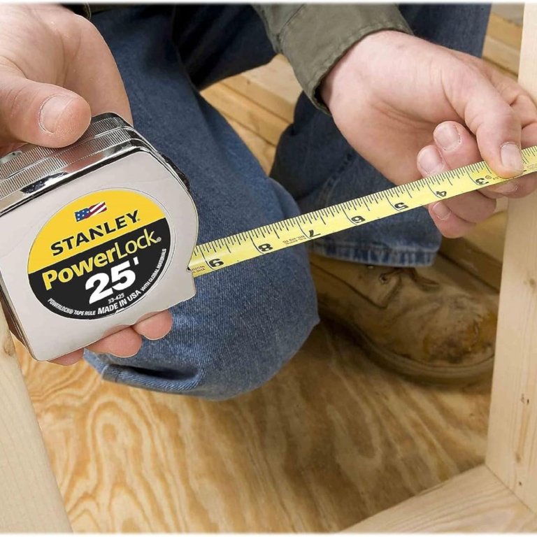 A person using the Stanley 25-Foot PowerLock Tape Measure to measure framing during testing