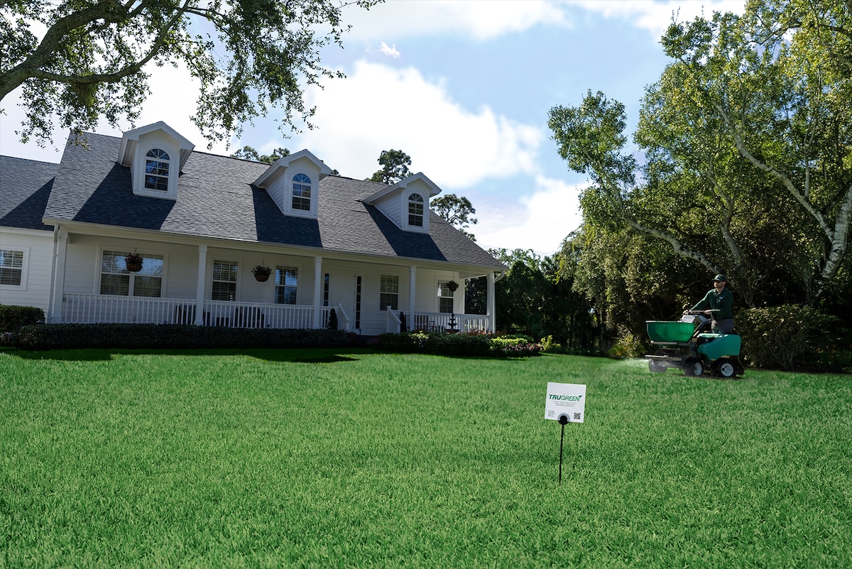 A TruGreen expert treating a spring lawn to get rid of weeds.