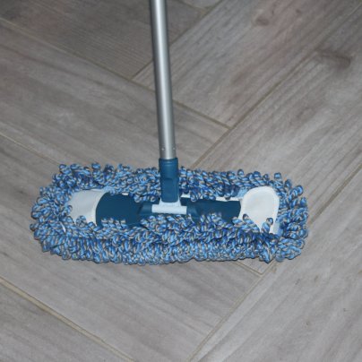 A product tester using the TrueYee dust mop on a tile floor