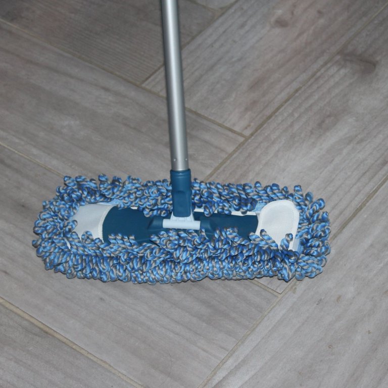 A product tester using the TrueYee dust mop on a tile floor