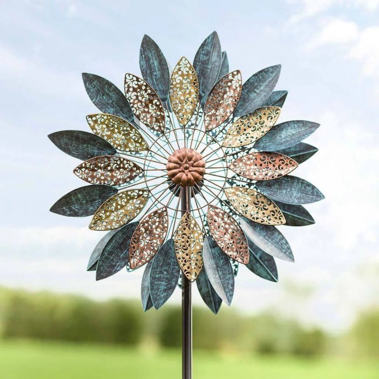 The Wind & Weather Metal Abstract Flower Wind Spinner with outdoor scenery in the background
