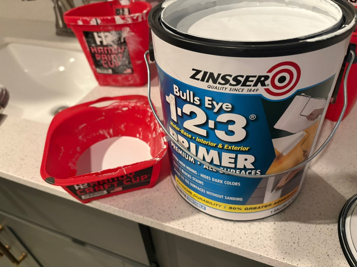 A can of Zinsser 123 drywall primer next to a paint bucket during testing