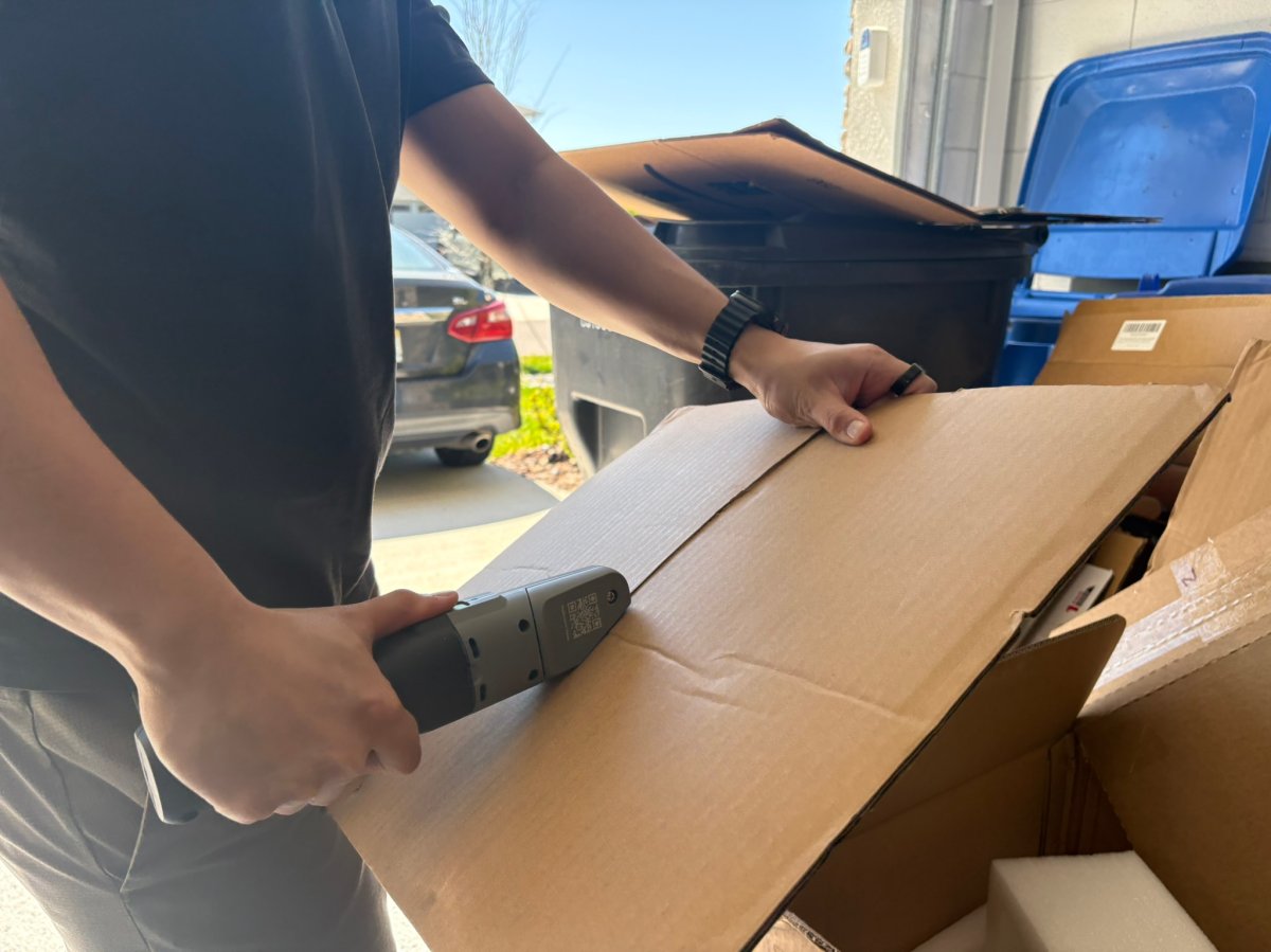 A product tester using the Boxblayde electric cardboard cutter to break down a cardboard box