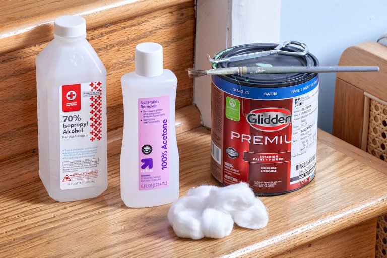 Isopropyl alcohol, nail polish remover, a gallon of paint and cotton balls are positioned on an interior wooden staircase.