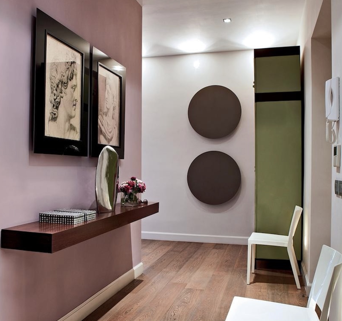 A stylish a modern hallway with an accent wall painted in Farrow & Ball's "Cinder Rose" paint. 