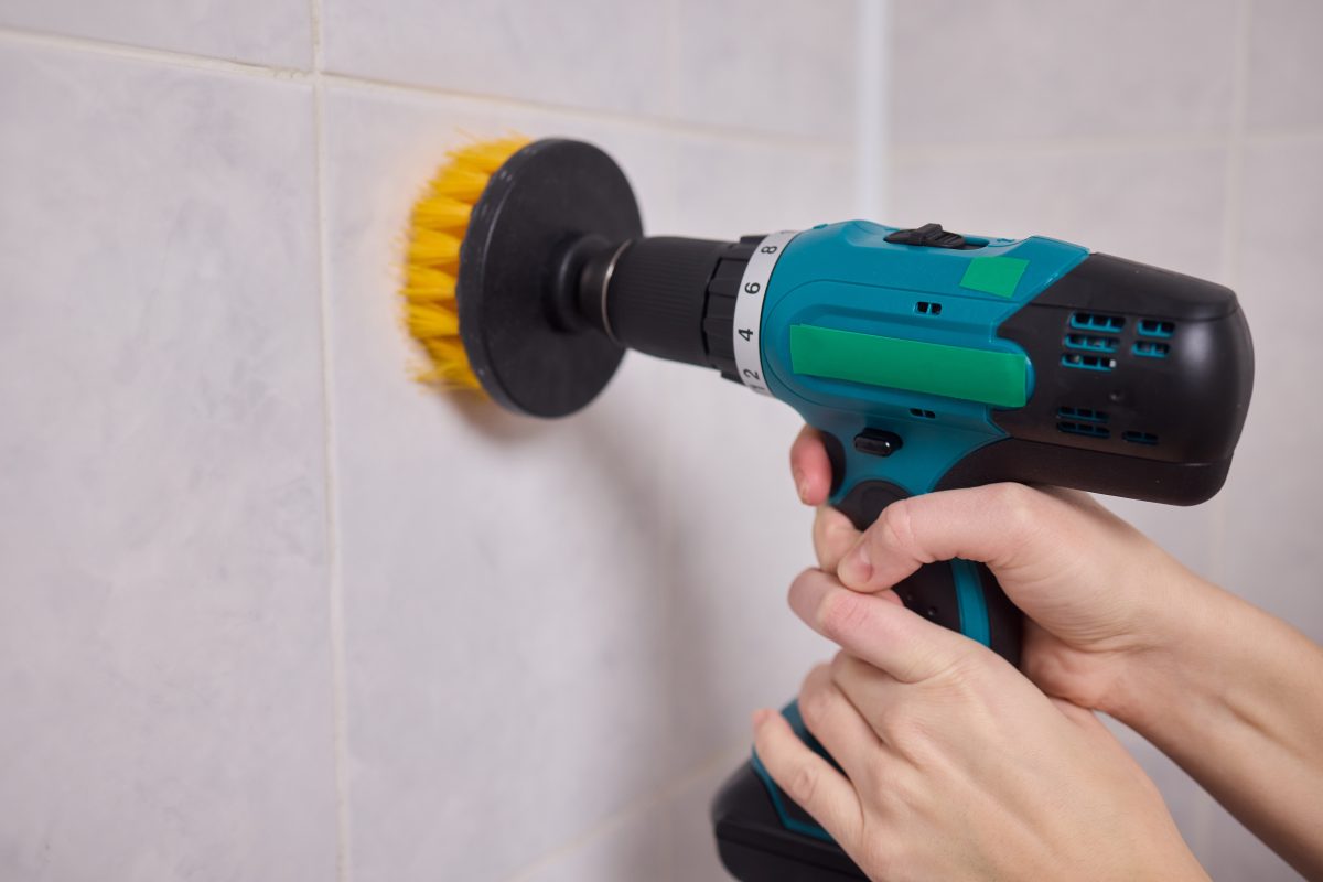Electric drill brush attachment cleaning shower tile.