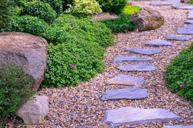 Stone stepping Walkway among lawn in a Japanese style garden. Landscaping in the garden