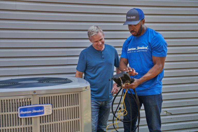 A homeowner talking with an American Standard heat pump installer.