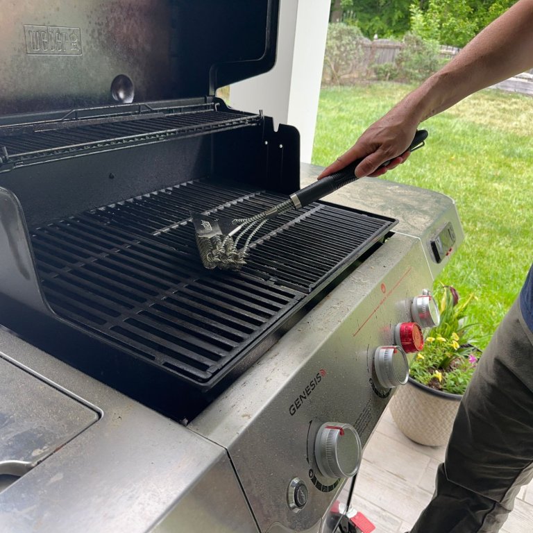 A person using the GrillArt Bristle-Free 17” Brush and Scraper during testing