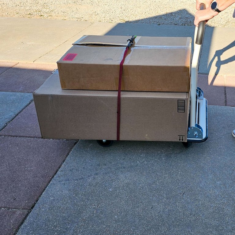 A person using the Lifetime Foldable Push Cart Dolly to move several large boxes during testing