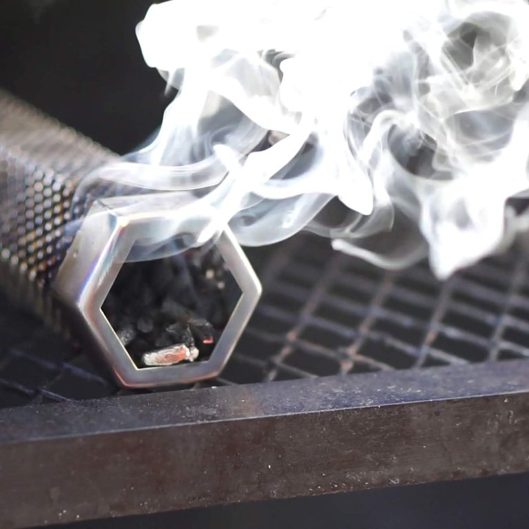The LizzQ Premium Pellet Smoker Tube smoking on a grill grate