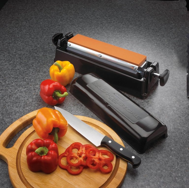 The Norton IM313 Multi-Oilstone Sharpening System next to a cutting board with bell peppers