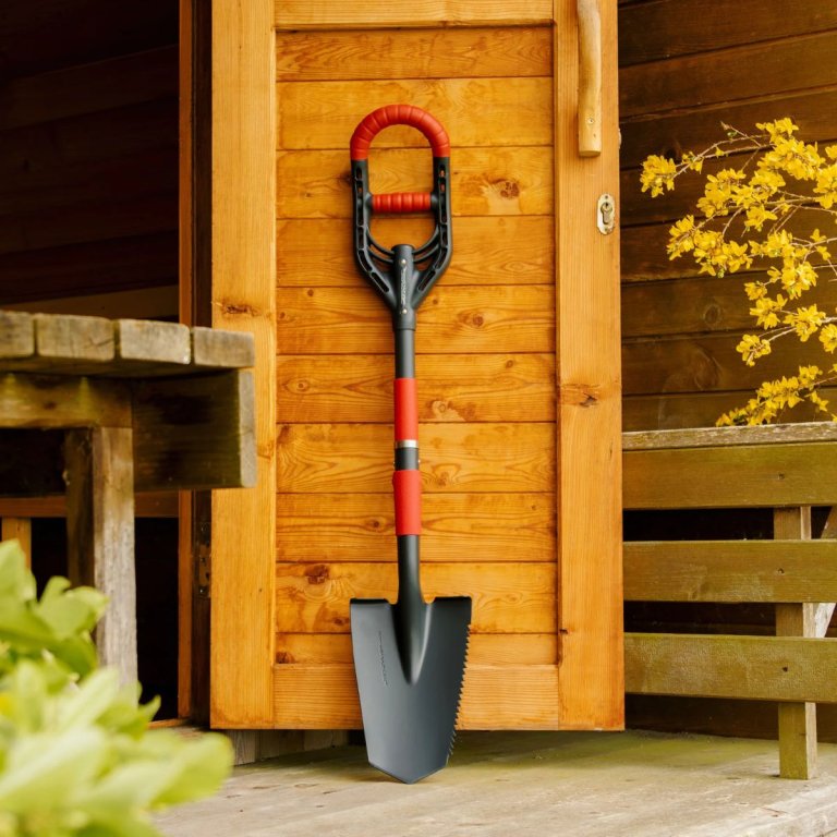 The Roamwild multi-digger garden spade leaning up against an open shed door
