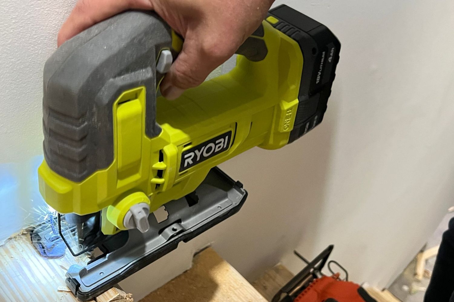 The Ryobi jigsaw in a product tester's hand in their workshop during testing