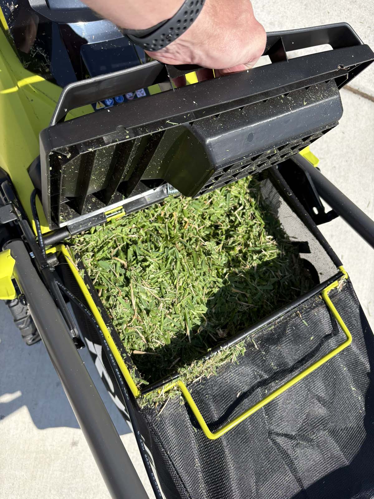Ryobi small lawn mower full of grass