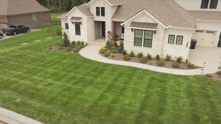 A perfectly manicured healthy lawn in front of a house.