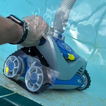 A person making an adjustment to the Zodiac MX6 Advanced Suction Mechanical Pool Cleaner during testing