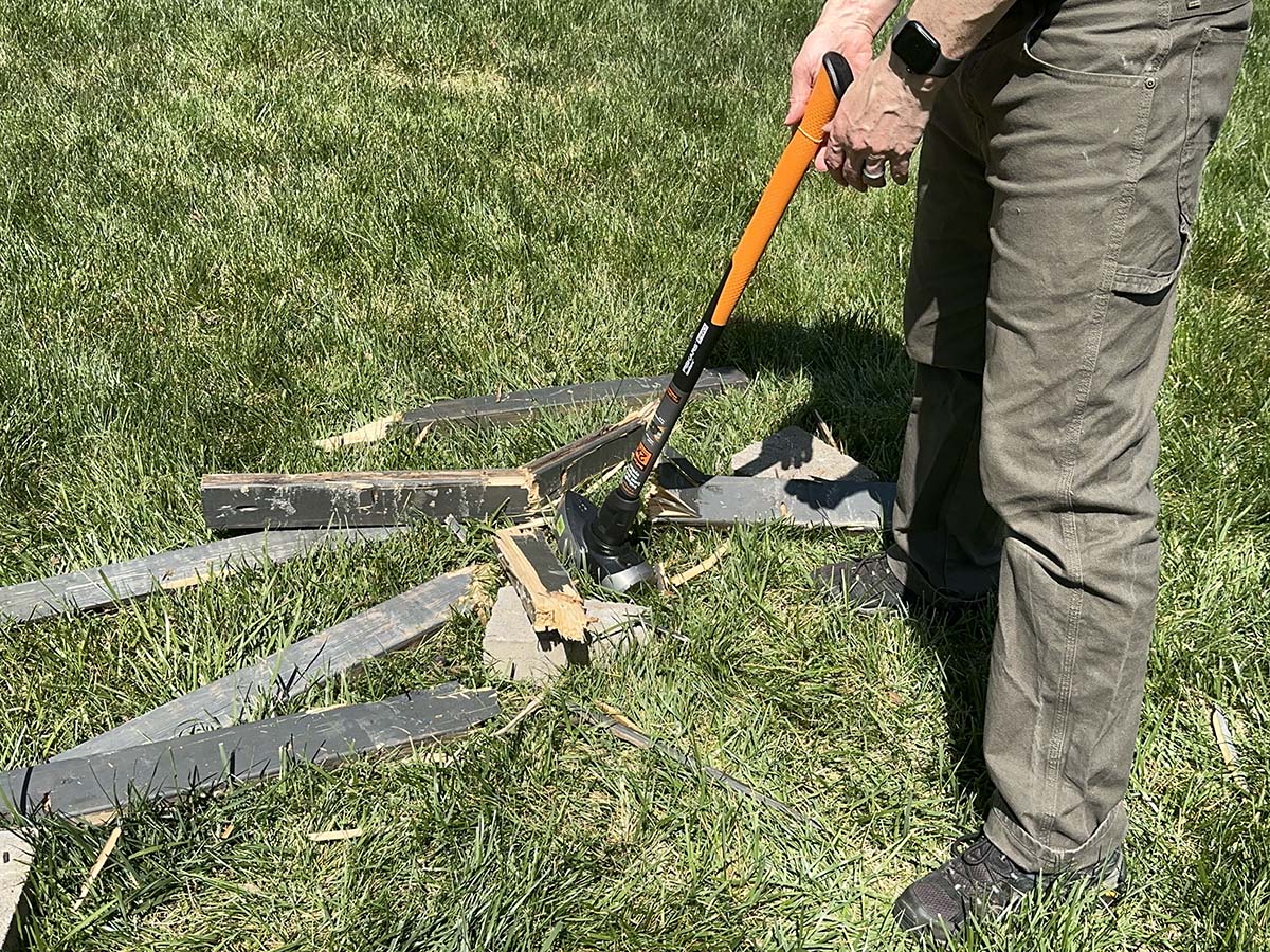 A person using one of the best sledgehammers to break apart fencing during testing