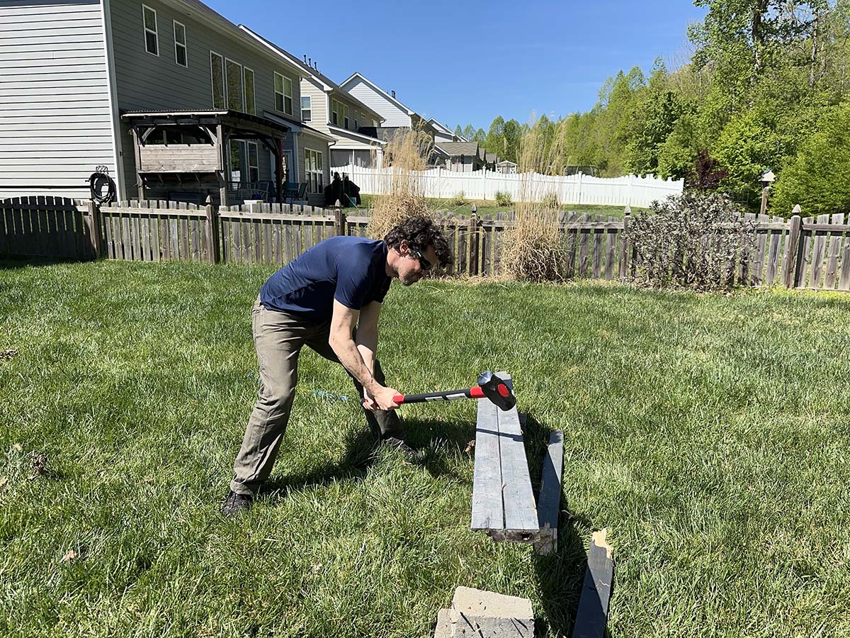 A person using one of the best sledgehammers to break apart fencing during testing