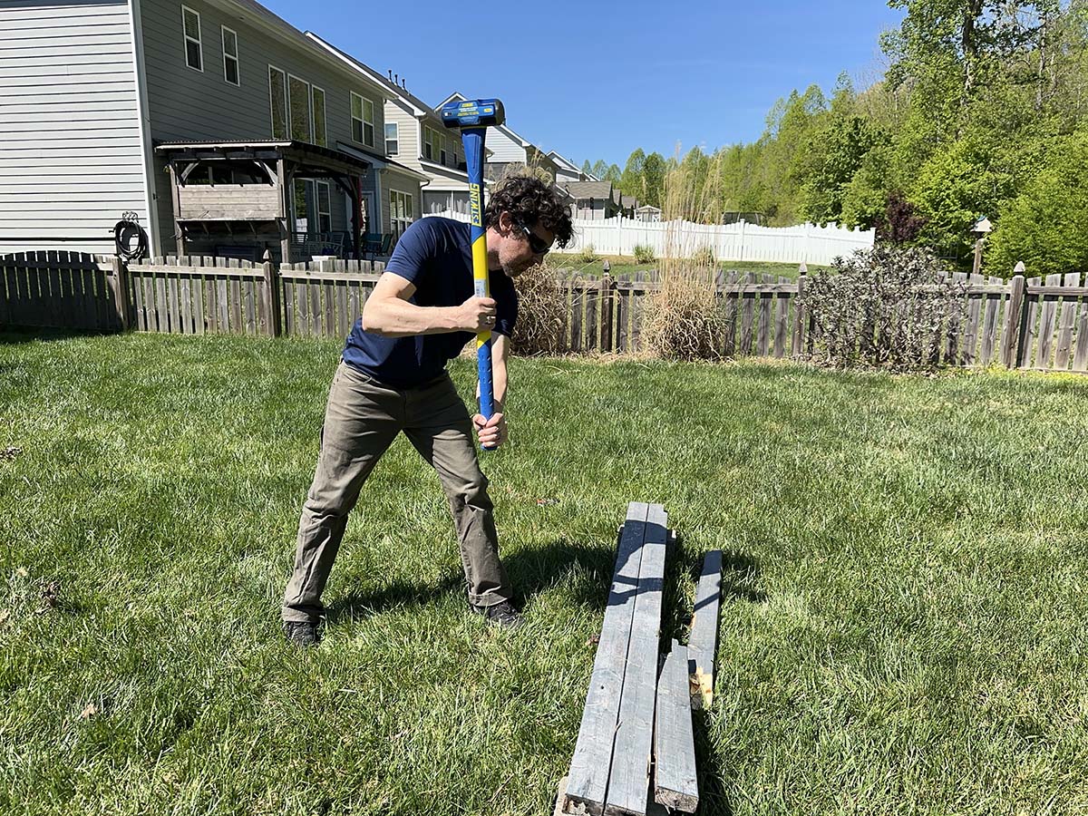 A person using one of the best sledgehammers to break apart fencing during testing