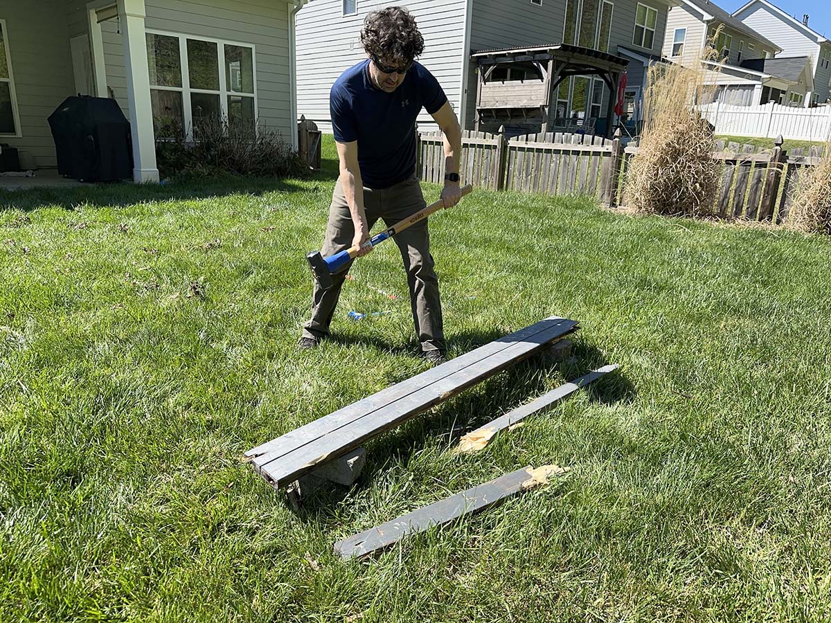 A person using one of the best sledgehammers to break apart fencing during testing